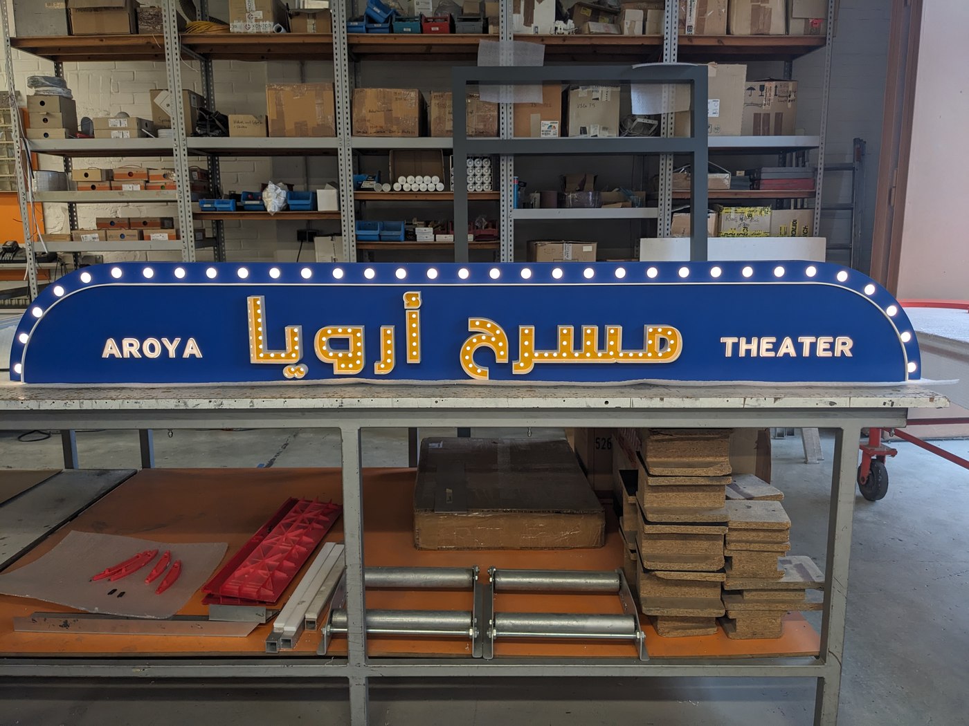 Aroya-Theater — fertige blaue Marquee mit Lichterkranz, lateinisch und arabisch