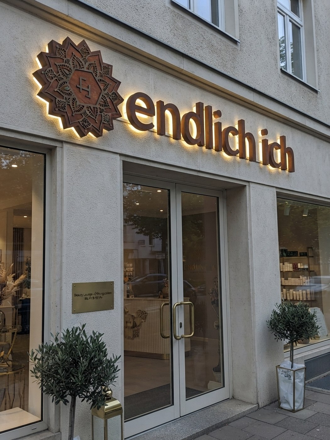 endlich ich — Schriftzug mit Mandala-Emblem an der Fassade der Beauty-Lounge