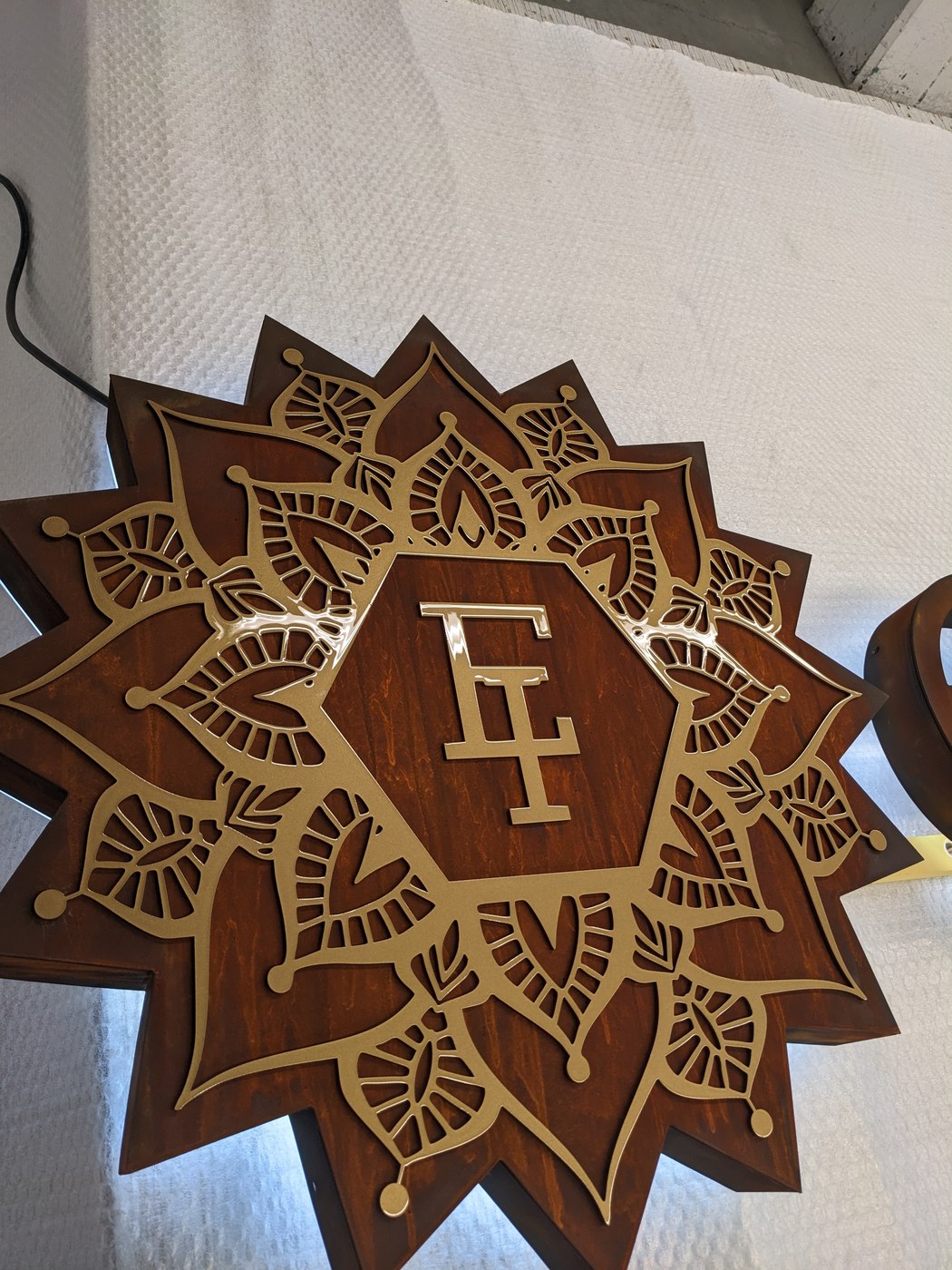 endlich ich — Mandala-Emblem mit EI-Monogramm, goldene dekupierte Ornamente
