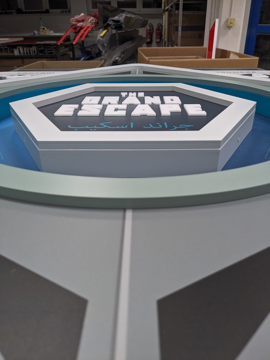 Grand-Escape-Hexagon-Zeichen unbeleuchtet auf runder Basis in der Werkstatt
