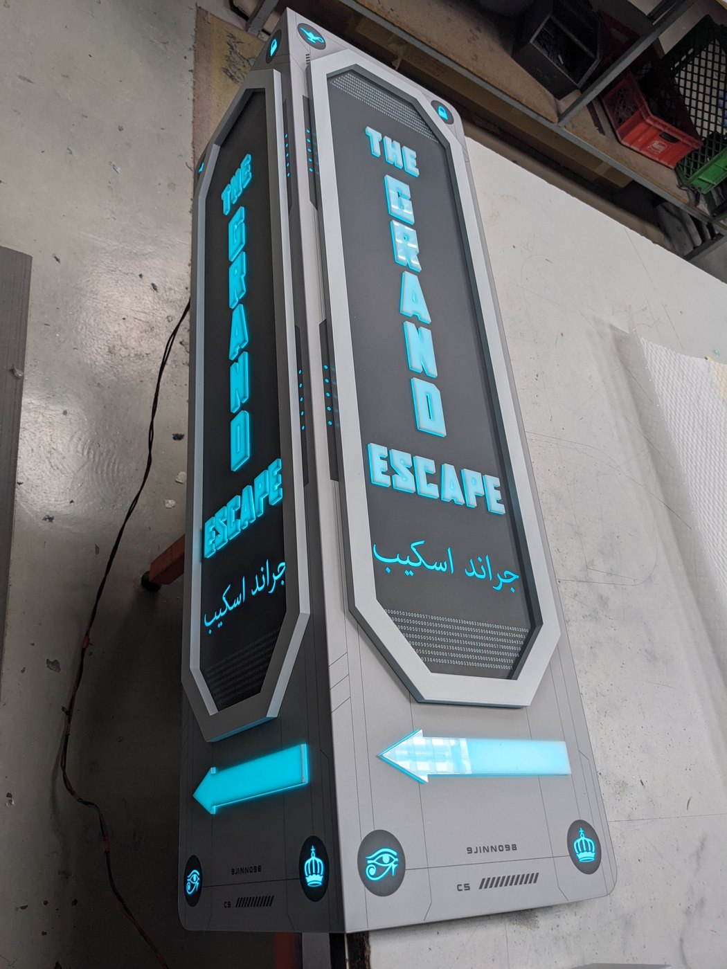 Beide Grand-Escape-Stelen türkis beleuchtet, THE GRAND ESCAPE mit Richtungspfeilen