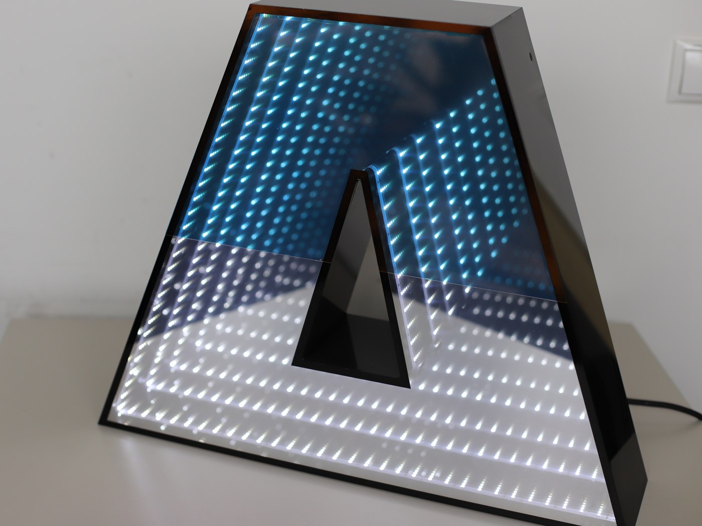 Großer Buchstabe A — Infinity-Lichttunnel von Blau in Weiß, formatfüllend