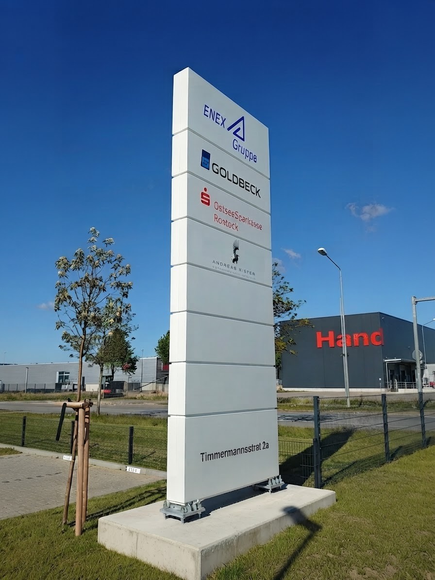 Freistehender Sammelpylon auf Betonfundament in Rostock — acht Mieterfelder von ENEX über GOLDBECK bis OstseeSparkasse