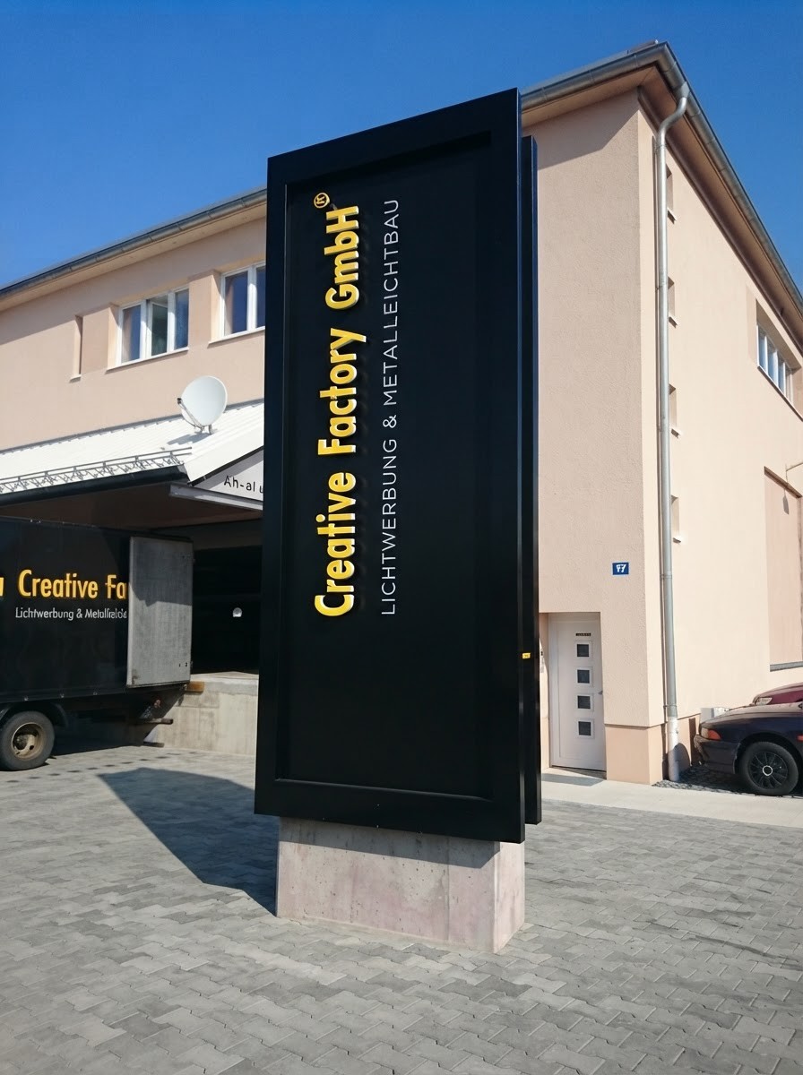 Creative Factory GmbH — eigener Pylon am Standort Großenhain, schwarzer Korpus mit goldenen Profilbuchstaben